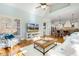 Bright living room featuring plantation shutters, hardwood floors, and an open-concept design with kitchen view at 209 Democracy Pl, Apex, NC 27523