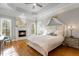 Luxurious main bedroom suite featuring a fireplace, tray ceiling, and abundant natural light at 209 Democracy Pl, Apex, NC 27523