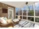 Relaxing screened porch with brick accent wall and large windows overlooking the wooded lot at 209 Democracy Pl, Apex, NC 27523