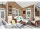 Comfortable screened porch seating area with brick walls and a striped rug for added charm at 209 Democracy Pl, Apex, NC 27523