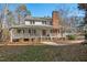 Charming two-story home with a brick chimney and a welcoming front porch, surrounded by mature trees at 226 Riverforest Dr, Hillsborough, NC 27278