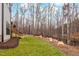 Spacious backyard features a lush green lawn, rock features and mature trees at 227 Beech Slope Ct, Chapel Hill, NC 27517