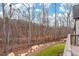 View of the backyard featuring mature trees, a boulder-lined garden, and a fence at 227 Beech Slope Ct, Chapel Hill, NC 27517