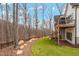 Backyard featuring a lush green lawn, wooded area, and a deck with black railings offering serene outdoor living at 227 Beech Slope Ct, Chapel Hill, NC 27517