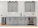 Modern bar area with gray cabinets, a beverage refrigerator, and a white tile backsplash at 227 Beech Slope Ct, Chapel Hill, NC 27517