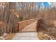Scenic wooden walking bridge surrounded by trees, offering a serene and natural outdoor experience at 227 Beech Slope Ct, Chapel Hill, NC 27517