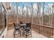 Back deck with a table and four chairs offering a view of the wooded backyard at 227 Beech Slope Ct, Chapel Hill, NC 27517