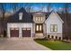 Elegant two-story home featuring a stone and white facade, complemented by a well-manicured lawn and mature trees at 227 Beech Slope Ct, Chapel Hill, NC 27517