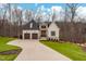 Inviting two-story house boasts a stone and white exterior, accented by a long driveway and lush green lawn at 227 Beech Slope Ct, Chapel Hill, NC 27517