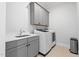 Laundry room features modern washer, dryer, sink, and storage cabinets at 227 Beech Slope Ct, Chapel Hill, NC 27517