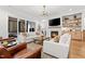 Living room with white sofas, fireplace, TV, and access to covered patio at 227 Beech Slope Ct, Chapel Hill, NC 27517
