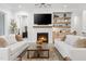 Bright living room with fireplace, TV, floating shelves and white sofas at 227 Beech Slope Ct, Chapel Hill, NC 27517