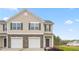 Beautiful townhome showcasing the detailed stone accents, gray door, and newly landscaped yard at 268 Moyer Dr, Graham, NC 27253