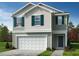 Two story home with shaker siding, a white garage door, a concrete driveway, and dark green shutters at 2701 Princess Tree Dr, Raleigh, NC 27616