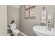 Elegant half-bathroom with a modern sink, toilet, and decorative wall art at 272 Moyer Dr, Graham, NC 27253