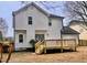 A view of a house's rear exterior, featuring a deck, white siding, and black framed doors at 3 Azzi Ct, Durham, NC 27703