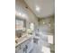 The pristine bathroom features a luxurious soaking tub, marble-look tile, and elegant vanity with modern fixtures at 3 Azzi Ct, Durham, NC 27703