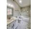 The pristine bathroom features a luxurious soaking tub, marble-look tile, and elegant vanity with modern fixtures at 3 Azzi Ct, Durham, NC 27703