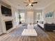 A living room with a fireplace, television, a modern sofa and a ceiling fan at 3 Azzi Ct, Durham, NC 27703
