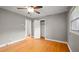 Bedroom with hardwood floors, ceiling fan, closet, window, and connecting doorway to the hall at 316 Watson Dr, Burlington, NC 27217