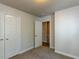Bedroom with neutral walls, carpet and trim, and open door at 3553 E Jameson Rd, Raleigh, NC 27604