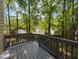 Back deck with wooden railings overlooking a wooded yard at 3553 E Jameson Rd, Raleigh, NC 27604