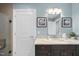 Bathroom with a dark vanity, granite countertop, framed mirror, glass shower, and soft blue walls at 400 W North St # 730, Raleigh, NC 27603