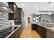 Modern kitchen featuring dark wood cabinetry, granite countertops and backsplash, and stainless steel appliances at 400 W North St # 730, Raleigh, NC 27603