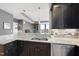 Kitchen sink area with granite countertops, dark cabinets, stainless steel dishwasher, and modern fixtures at 400 W North St # 730, Raleigh, NC 27603