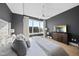 Bedroom with hardwood floors, gray accent wall, ceiling fan, TV and large windows with great city views at 400 W North St # 730, Raleigh, NC 27603