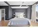 Bedroom with hardwood floors, gray accent wall, ceiling fan and large windows with great city views at 400 W North St # 730, Raleigh, NC 27603