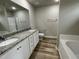 Bright bathroom features a granite countertop, dual sinks and white cabinetry at 416 Magnolia Run Way, Benson, NC 27504