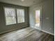 Bedroom with a door leading to the balcony and two windows providing natural light, creating a cozy atmosphere at 416 Magnolia Run Way, Benson, NC 27504