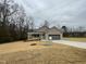 Attractive single-Gathering home with a two-car garage and a cozy front porch, nestled among bare trees at 416 Magnolia Run Way, Benson, NC 27504