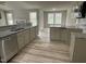 Bright kitchen with granite countertops, stainless steel appliances, and wood-look floors, open to living area at 416 Magnolia Run Way, Benson, NC 27504