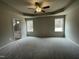 Spacious main bedroom with a tray ceiling, neutral carpet, two windows and ensuite bathroom with tub at 416 Magnolia Run Way, Benson, NC 27504