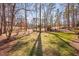 Spacious backyard with lush green grass, surrounded by mature trees and landscaping, offering privacy and tranquility at 43 New Rhododendron, Chapel Hill, NC 27517