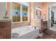 Bathroom featuring a soaking tub, decorative window, and tiled accents at 43 New Rhododendron, Chapel Hill, NC 27517