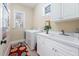 Bright laundry room featuring white cabinets, sink, washer, dryer, and tiled floors for convenience at 43 New Rhododendron, Chapel Hill, NC 27517