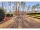 Community playground with swings and benches surrounded by trees at 43 New Rhododendron, Chapel Hill, NC 27517