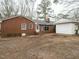 The backyard of a red brick home, featuring a small stoop and a detached carport at 431 Mattox St, Wendell, NC 27591