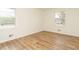 Bright bedroom featuring new wood laminate flooring, dual windows, and fresh neutral paint at 431 Mattox St, Wendell, NC 27591