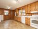 Well-lit kitchen features wood-paneled walls, classic cabinets, and tiled floors for a rustic aesthetic at 431 Mattox St, Wendell, NC 27591