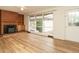 Cozy living room featuring a wood-burning stove, brick hearth, and updated wood laminate flooring at 431 Mattox St, Wendell, NC 27591