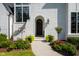 Charming front entrance with an arched doorway, black door, beautiful plants, and exterior lantern lighting at 5137 Avalaire Oaks Dr, Raleigh, NC 27614