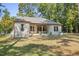 Spacious backyard with a covered patio, lush lawn, and mature trees at 5750 Nc Highway 49, Burlington, NC 27215