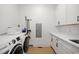 Laundry room featuring white cabinets, sink, quartz countertop, and stainless steel appliances at 5750 Nc Highway 49, Burlington, NC 27215