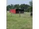 Outdoor shot of a red barn, a metal gate, and a horse in a pasture at 7027 Old 421 Rd, Liberty, NC 27298