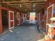 Well-lit barn interior featuring multiple horse stalls and an organized layout at 7027 Old 421 Rd, Liberty, NC 27298