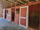 Barn interior featuring horse stalls with metal doors, providing a secure and functional space at 7027 Old 421 Rd, Liberty, NC 27298